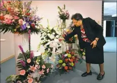  ?? Nate Guidry/Post-Gazette ?? Karen West Butler, owner of West Funeral Home in the Hill District, arranges flowers before a funeral visitation Monday. West Funeral Home, founded 85 years ago, is among the black-owned businesses in the Pittsburgh region.