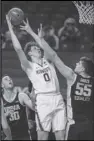  ?? Associated Press ?? TALL ORDER — Minnesota center Liam Robbins (0) shoots against Iowa center Luka Garza (55) during the first half on Friday in Minneapoli­s. Minnesota upset No. 4 Iowa 102-95 in overtime.