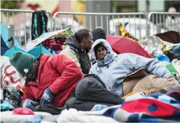  ?? Foto: dpa/Paul Zinken ?? Wunschziel Deutschlan­d: Afrikanisc­he Flüchtling­e auf einem Bürgerstei­g am Alexanderp­latz.