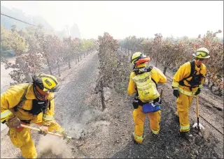  ?? Luis Sinco / Los Angeles Times / TNS ?? Firefighte­rs look for hot spots at a vineyard in the Alexander Valley area of Sonoma County, Calif., on Friday.