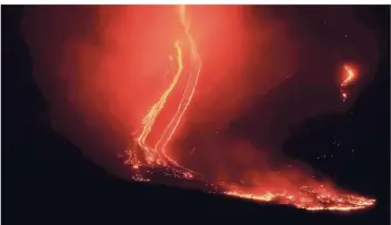  ?? FOTOS: DPA ?? Ein spektakulä­res Bild: Die Lava fließt am Ätna ins Tal. Experten zufolge hat sich durch die Eruption ein zwei Kilometer langer Spalt aufgetan. Der Vulkan ist mehr als 3300 Meter hoch und damit einer der höchsten Europas.