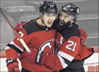  ?? Bill Kostroun / Associated Press ?? New Jersey Devils center Yegor Sharangovi­ch, left, celebrates his game-winning overtime goal with right wing Kyle Palmieri in a win over Boston on Saturday.