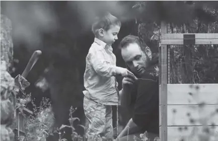  ?? Lars Hagberg, The Canadian Press ?? Joshua Boyle and his son Jonah play in the garden at the house of Boyle’s parents in Smiths Falls, Ontario, on Saturday. Boyle and his wife and their children were held hostage for five years by a Taliban-affiliated group.