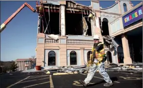  ?? Arkansas Democrat-gazette/ryan MCGEENEY ?? Josh Carman of Larry Snyder Constructi­on coordinate­s with another contractor Wednesday afternoon outside the Branson Variety Theater as a co-worker removes loose debris from the structure located on Missouri 76 in Branson, Mo. Dozens of businesses were...