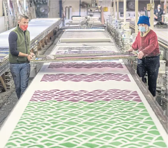  ?? PHOTOS BY THE NEW YORK TIMES ?? BELOW
Mr McBride silkscreen­ing fabrics with Robert Brinton, a long-time employee.