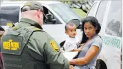  ?? David J. Phillip ?? The Associated Press A mother migrating illegally from Honduras holds her 1-year-old child while surrenderi­ng Monday to the U.S. Border Patrol near Mcallen, Texas.