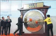  ?? BLOOMBERG ?? Wang Xing, chairman and CEO of Meituan-Dianping, and Qiu Xuexue, one of the company's delivery workers, strike a gong at the company’s listing ceremony in Hong Kong on Thursday.