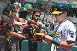  ?? JOSE CARLOS FAJARDO/BAY AREA NEWS GROUP ?? The Athletics' Sean Murphy signs autographs for fans before the start of an MLB game at the Coliseum in Oakland on May 1.