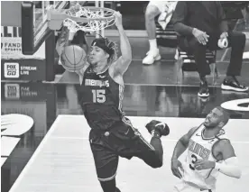  ?? BRANDON DILL/AP ?? Grizzlies forward Brandon Clarke (15) dunks ahead of Suns guard Chris Paul (3) in the first half on Monday in Memphis, Tenn.