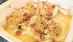  ?? GRETCHEN MCKAY/PITTSBURGH POST-GAZETTE ?? Baked cod is topped with lemon butter, garlicky tomatoes and a Parmesan-panko crust for a simple but satisfying supper.