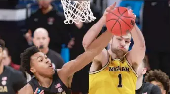  ?? JUSTIN CASTERLINE/GETTY IMAGES ?? Michigan’s Hunter Dickinson battles Florida State’s Scottie Barnes for a rebound.