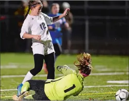  ?? SEAN D. ELLIOT/ THE DAY ?? Old Lyme’s Mya Johnson pokes the ball past St. Paul goalie Nina Zwolinski for a goal during the Wildcats’ 4-2 victory over the Falcons in Tuesday’s CIAC Class S girls’ soccer tournament semifinal at Falcon Field in Meriden. Old Lyme will play Holy...