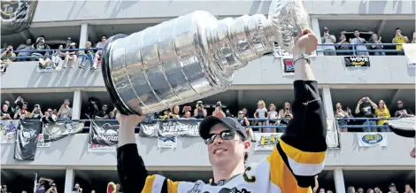  ?? GENE J. PUSKAR/AP ?? Pittsburgh captain Sidney Crosby hoists the Stanley Cup during the Penguins’ Stanley Cup parade in June in Pittsburgh. Crosby turns 30 on Monday and will celebrate with the Stanley Cup while serving as parade marhsal in Halifax’s annual Natal Day parade.