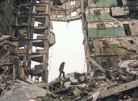  ?? ?? A resident looks for belongings in a destroyed apartment building on April 5 in Borodyanka, Ukraine. Friday marks a full year of killing, destructio­n, loss and pain felt even beyond the borders of Russia and Ukraine.