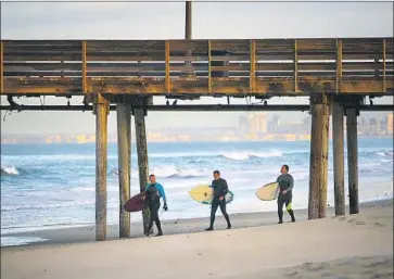  ?? Nelvin C. Cepeda San Diego Union-Tribune ?? IMPERIAL BEACH has long been a source of complaints from surfers, such as these by the pier, about foul odors along the shoreline in the summer. A new report says raw sewage is traveling up the coast from Mexico.