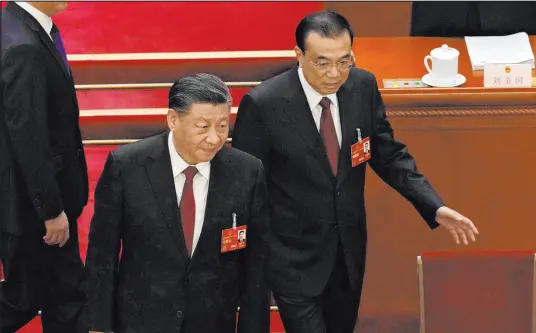  ?? Ng Han Guan The Associated Press ?? Chinese Premier Li Keqiang, right, walks near Chinese President Xi Jinping on Sunday during the opening session of China’s National People’s Congress in Beijing. Li is leaving and may be remembered for the fact he wasn’t seen purely as a Xi loyalist.