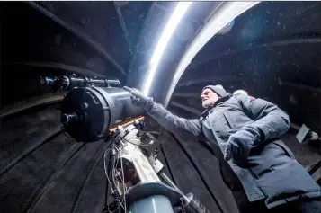  ?? Herald photo by Ian Martens @IMartensHe­rald ?? Lethbridge Astronomy Society member Tom Anderson points out features on the group’s largest telescope, a 14-inch Schmidt-Cassegrain, at the Oldman River Observator­y. The society and University of Lethbridge researcher­s have concerns about light pollution encroachin­g on the remaining patch of dark sky that can be seen from the Popson Park location.