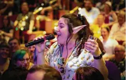  ??  ?? A passenger sings on opening night of the cruise, which often is described as “nerd summer camp at sea.”