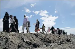  ??  ?? Rohingya Muslims from Myanmar trek to a camp for refugees in Teknaf, Bangladesh in this October photo from last year.