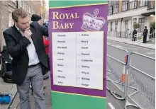  ?? LEON NEAL/AFP/ GETTY IMAGES ?? A bookmaker poses with a list of possible baby names for the first child of the Duke and Duchess of Cambridge.