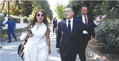  ?? (Zoubeir Souissi/Reuters) ?? PRESIDENTI­AL CANDIDATE Nabil Karoui and his wife Salwa Smaoui are seen in front of his house before Sunday’s runoff election in Tunis yesterday.