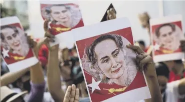  ??  ?? 0 Protesters hold images of detained Myanmar civilian leader Aung San Suu Kyi yesterday