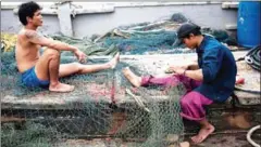  ?? NICOLAS ASFOURI/AFP ?? Migrant workers repair a net on a Thai fishing boat in Thailand’s Rayong province. Cambodian plaintiffs last week appealed a Thai court’s decision dismissing all charges against two suspects they accuse of traffickin­g them into the fishing industry.