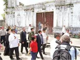  ??  ?? In this Feb. 27, 2015 file photo, French President Francois Hollande (center in dark suit) looks at the Immaculate Concepcion Church which was damaged by typhoon Haiyan in November, 2013 during his tour of the typhoon-ravaged Guiuan township, in...