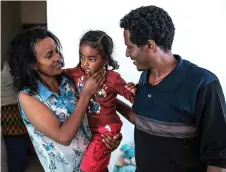  ?? — AFP photo ?? Getahun (right) and his wife Emebet Melaku cuddle their daughter in their home, in the city of Gondar, Ethiopia.