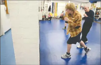  ?? NEWS FILE PHOTO ?? In this Jan. 16, 2013 file photo, boxing coach Bill Page, far right, works with Max Wilson at the Medicine Hat Boxing Club. Page, who passed away in 2016, was recently announced as one of 2021’s inductees for the Medicine Hat Sports Wall of Fame, alongside the Medicine Hat Hockey Hounds.