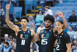  ?? CHRIS SEWARD/AP ?? Miami guard Jordan Miller, from left, forward Norchad Omier and guard Isaiah Wong react as one of their teammates sinks a free throw in the closing moments Monday against North Carolina in Chapel Hill.
