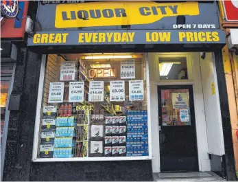  ?? FOTO: AFP ?? Ein Alkohollad­en im schottisch­ens Glasgow wirbt mit Tiefpreise­n: Dem neuen Gesetz für Mindestpre­ise ging ein jahrelange­r Rechtsstre­it voraus.