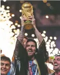  ?? MANU FERNANDEZ/ASSOCIATED PRESS ?? Argentina’s Lionel Messi holds up the trophy Sunday after Argentina won the World Cup by beating France at the Lusail Stadium in Lusail, Qatar.