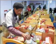  ??  ?? Mount Carmel Deacon Leroy Davis packs Thanksgivi­ng baskets in the basement of the church Friday. They will be given out to area residents in need Saturday.