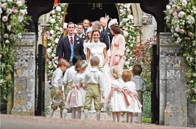  ??  ?? Pippa Middleton, (center) poses for a photograph with her new husband James Matthews.