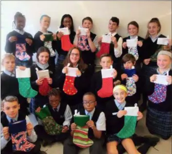  ?? SUBMITTED PHOTO ?? The sixth grade class at Notre Dame de Lourdes School in Swarthmore made stockings this week and collected donations for Stockings for Soldiers, an organizati­on that sends stockings to the troops overseas. Pictured with their stockings are Caroline Becker, Woodlyn; Eamon Bonsall, Swarthmore; Arshad Brown, Chester; Christian Dawson, Yeadon; Liam Geraghty, Brookhaven; Auria Greto, Woodlyn; Aubrey Harley, Swarthmore; Elizabeth Hoyer, Swarthmore; Remi Kolawole, Folcroft; Sebastian Lynn, Swarthmore; Amber Martusky, Woodlyn; Morgan Nickerson, Chester; Kevin Piffath, Folsom; Andrew Shay, Swarthmore; Emma Thornton, Upland; and Lillian Walsh, Upland.