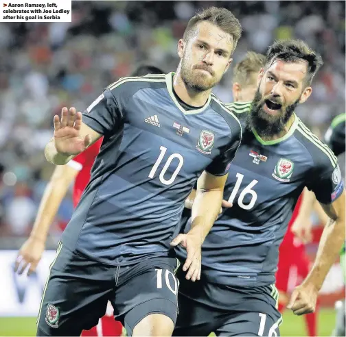  ??  ?? > Aaron Ramsey, left, celebrates with Joe Ledley after his goal in Serbia