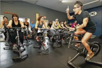  ?? CATHERINE AVALONE — NEW HAVEN REGISTER ?? Working hard — Guilford resident Lisa Peterson, owner of Lisa’s Bike and Bootcamp Studion at 53 East Industrial Road in Branford runs the On-Off Bike class, an intense one-hour workout using cycling and assault bikes, rowing machines, tires, dumbbells...