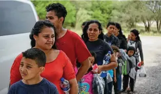  ?? Carolyn Van Houten / Washington Post file photo ?? Migrant families wait for transport in McAllen last June. Customs and Border Protection fears a recent surge of migrant families along the border could overwhelm the U.S. infrastruc­ture.