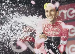  ??  ?? 0 Simon Yates sprays champagne on the podium at Mount Etna.