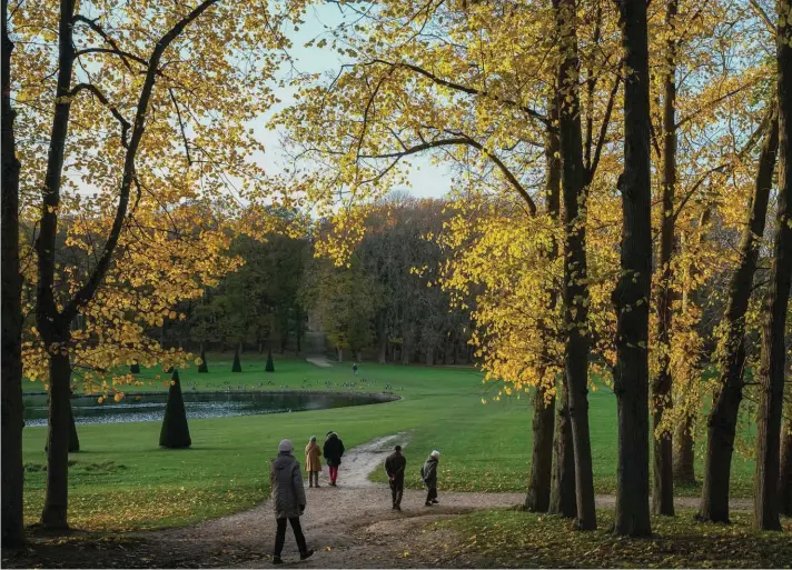  ?? Photo: Michel Euler/AP ?? People walk along the royal park of Marly le Roi, west of Paris, during sunset.