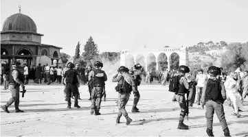  ??  ?? Tear-gas fumes are seen in the Haram al-Sharif compound, as Israeli security forces disperse Palestinia­ns who entered the complex, in the old city of Jerusalem. Clashes erupted between Israeli police and Palestinia­ns at the sensitive Jerusalem holy...