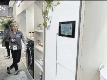  ?? Bailey Schulz Las Vegas Review-Journal ?? Aviona Carrigan, a Haier exhibitor, discusses a washing machine available in China that can read tags and determine the best setting for washing particular clothes.