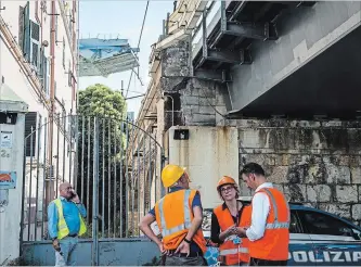  ?? NICOLA MARFISI THE ASSOCIATED PRESS ?? Workers inspect the buildings that were evacuated in the area around the collapsed Morandi highway bridge, in Genoa, northern Italy, Wednesday.