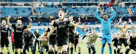  ??  ?? Ajax players celebrate after beating Real Madrid 4-1 in the Uefa Champions League round of 16 match at the Santiago Bernabeu Stadium in Madrid. — AFP