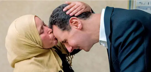  ??  ?? Regime In questa foto pubblicata sul suo profilo Facebook, il presidente siriano Bashar al Assad riceve un bacio da una parente di un uomo che sarebbe stato catturato dai ribelli (Afp)
