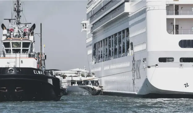  ?? PICTURE: GETTY IMAGES ?? 0 The damaged River Countess tourist boat (centre) after it was hit by the MSC Opera cruise ship (right) that lost control as it was coming in to dock.