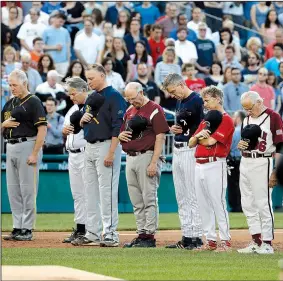  ?? AP/ALEX BRANDON ?? Republican­s and Democrats observe a moment of silence for Wednesday’s shooting victims, as the lawmakers take the field Thursday night at Nationals Park in Washington for their annual charity baseball game.