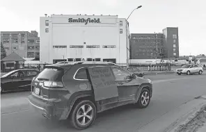  ?? ERIN BORMETT/ USA TODAY NETWORK ?? A car sporting a sign calling for a safe and healthy workplace drives past Smithfield Foods in Sioux Falls, S. D., on April 9 at a protest on behalf of employees during the COVID- 19 outbreak.