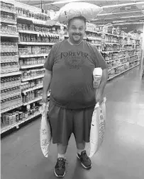  ?? COURTESY JODY GENESSY ?? Utah Jazz beat writer Jody Genessy uses sugar at a grocery store to illustrate how much weight he has lost so far on the way to his goal to lose 100 pounds before the start of the NBA season. He has lost 94 pounds so far.